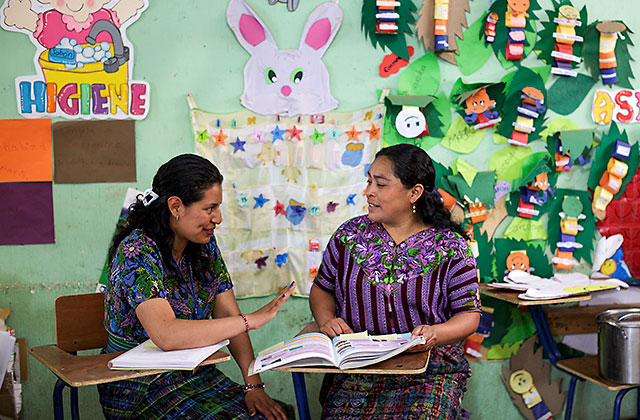 Child Aid literacy trainer meets with teacher at the El Sitio school.